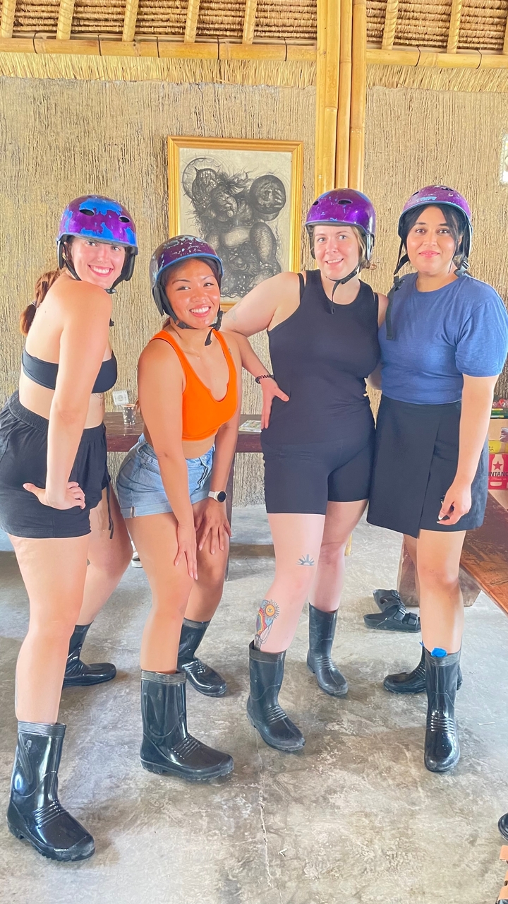 Groupe de quatre femmes posant à l'intérieur.