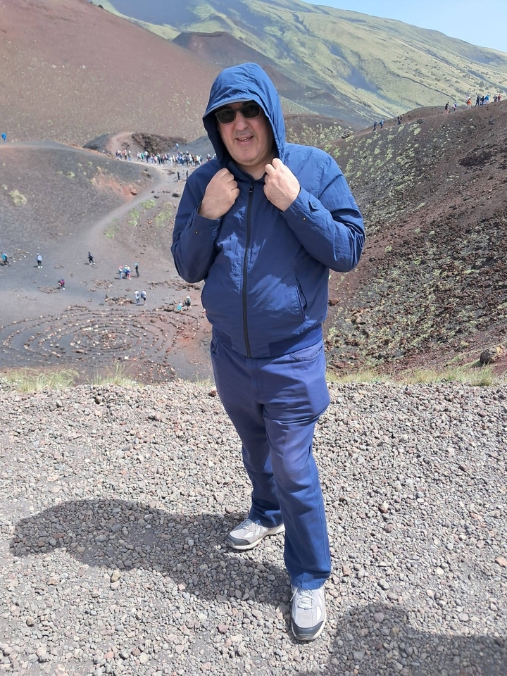Homme posant sur le terrain volcanique du mont Etna.