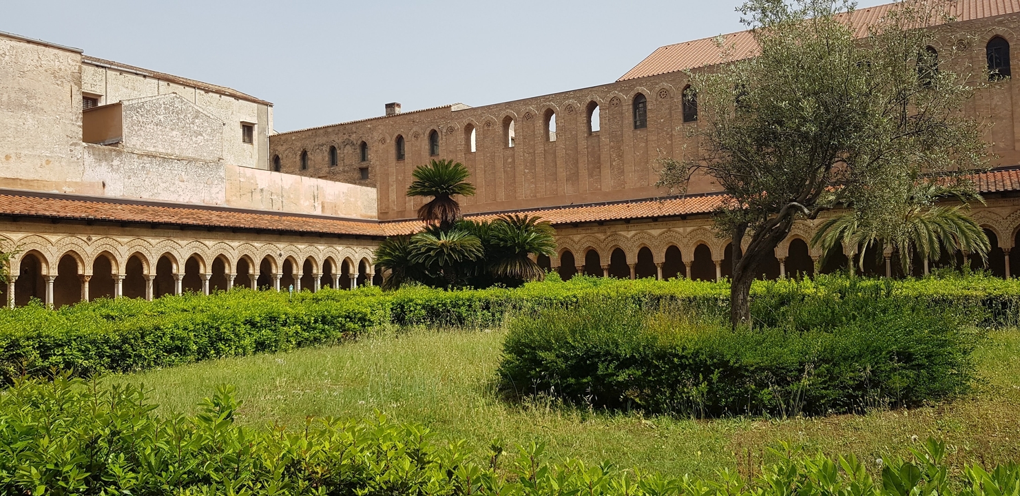 Cour avec arcades et végétation.