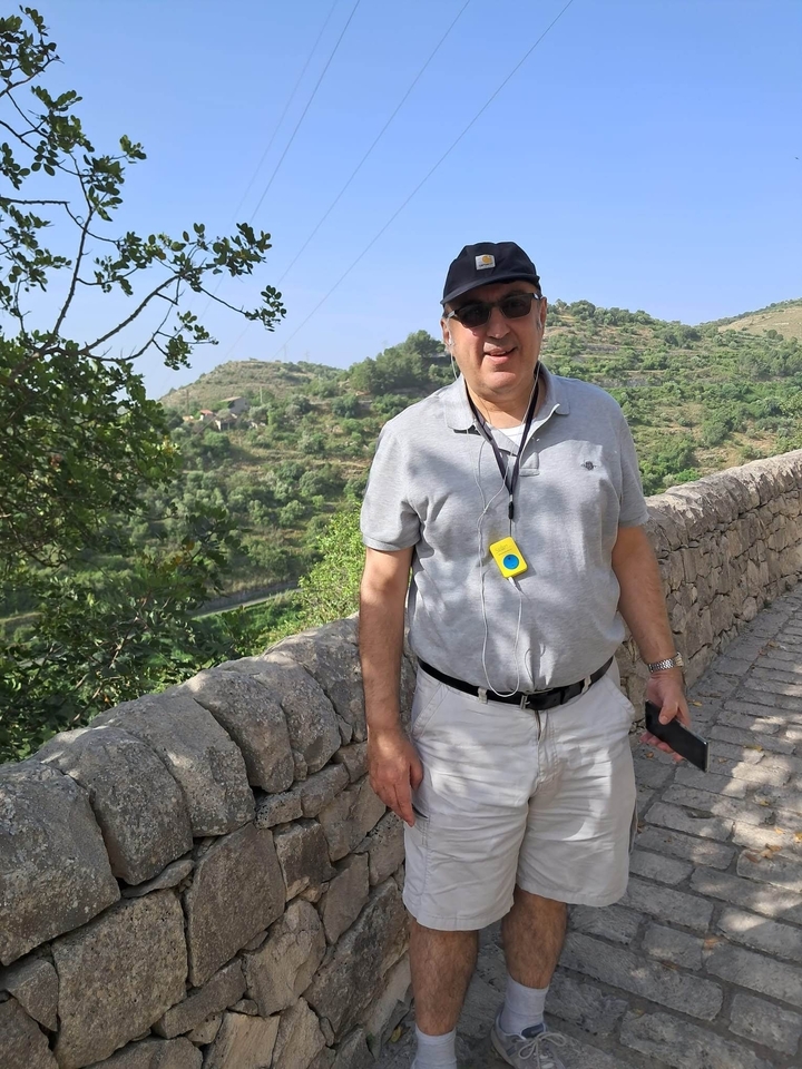 Homme posant sur une passerelle pittoresque.