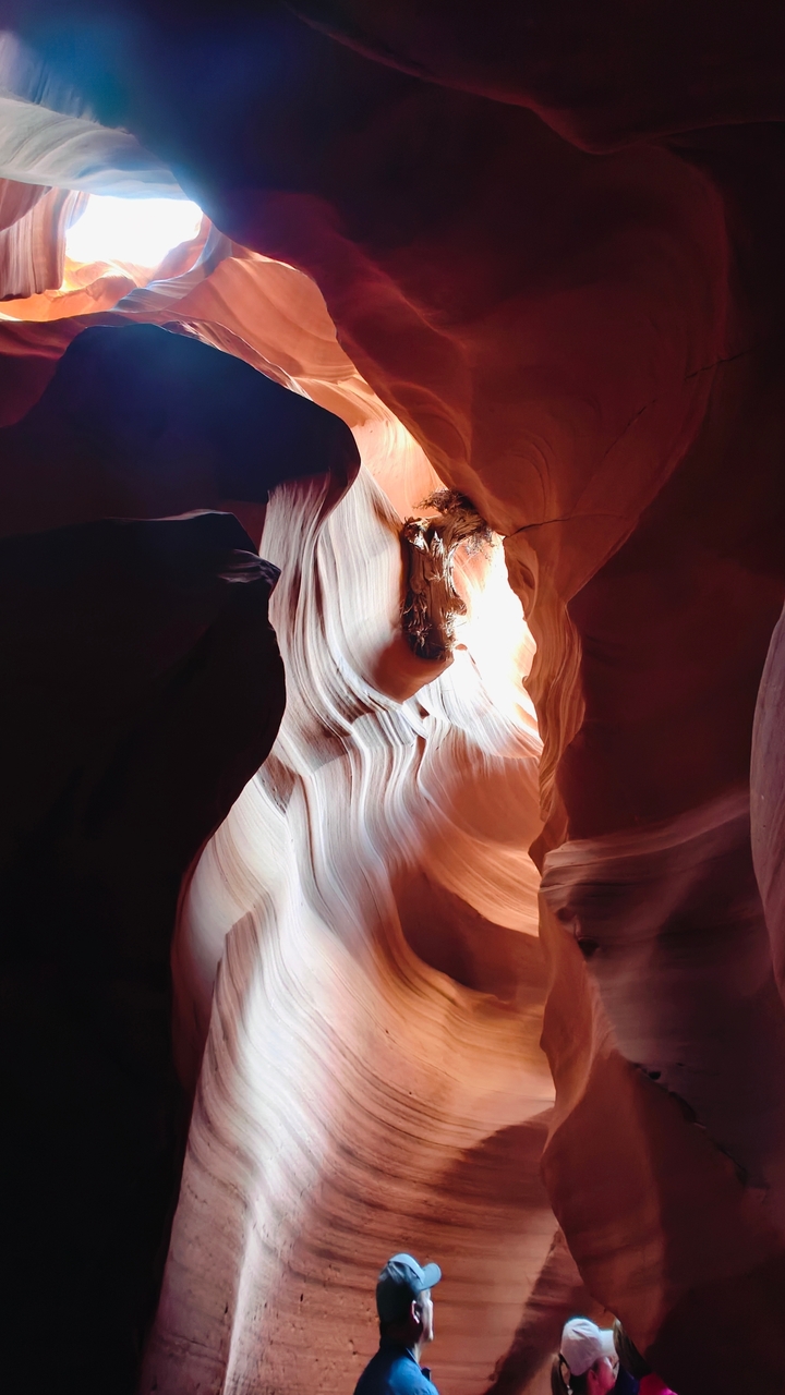 Intérieur d'un canyon avec des roches rouges lisses et de la lumière qui filtre à travers.