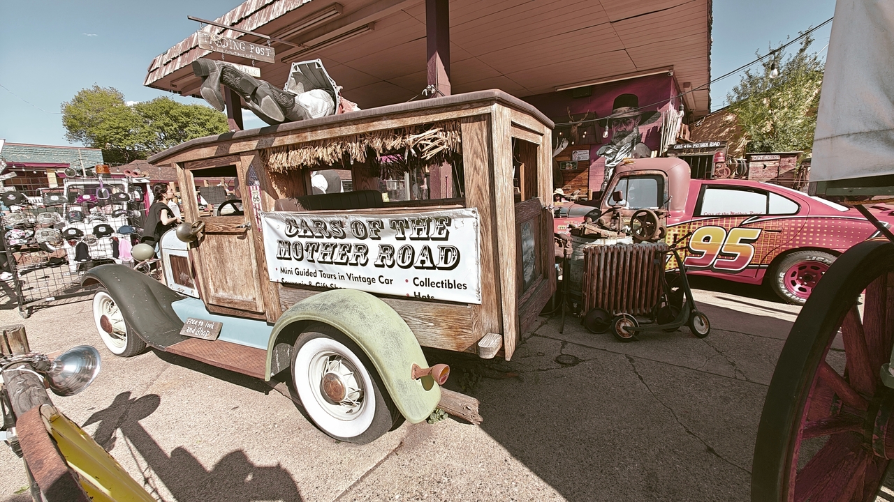 Collection de véhicules vintage et de panneaux de signalisation dans une attraction routière.