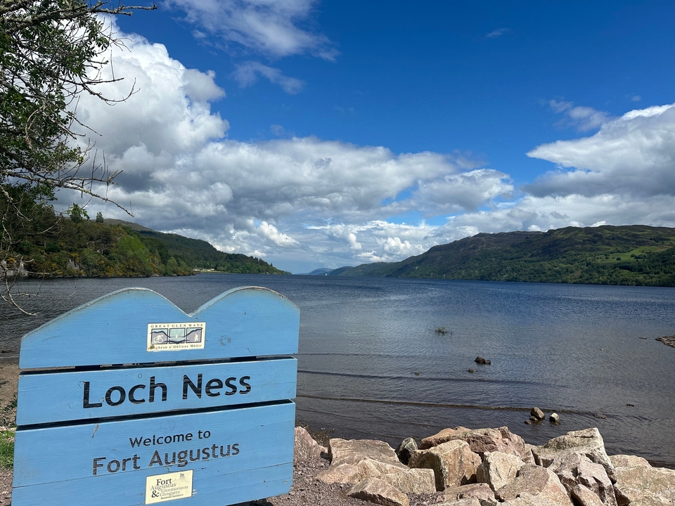 Loch Ness sign with a view of the lake.