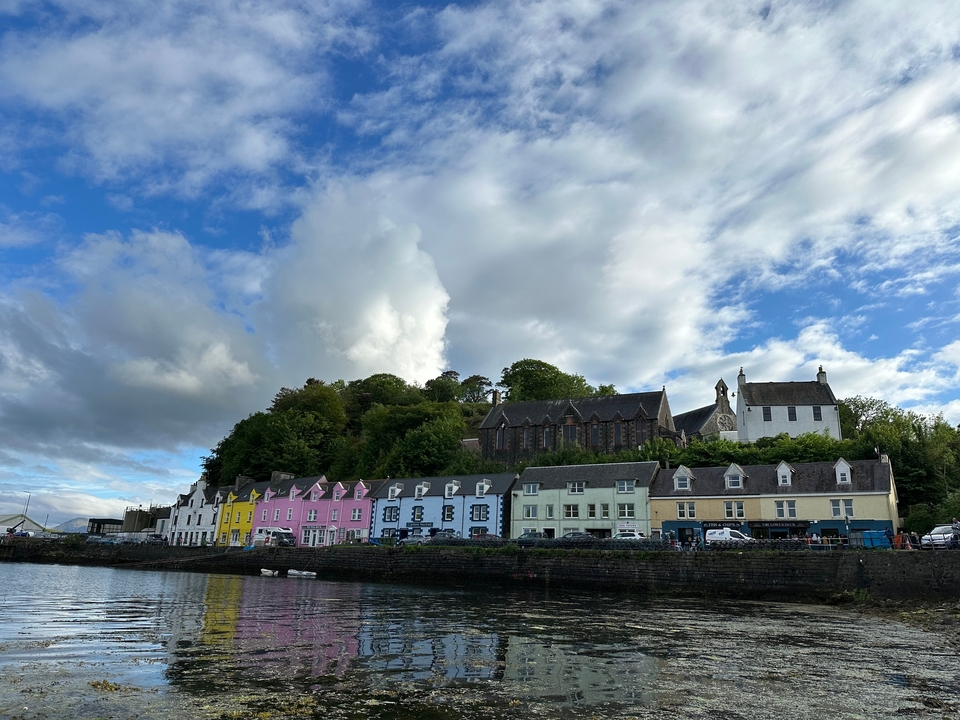 Colorful buildings by the waterfront under a cloudy sky.