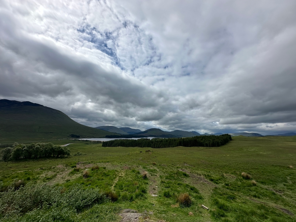 Rolling green hills under a cloudy sky.