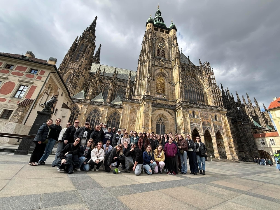 Groupe posant devant une cathédrale de style gothique.