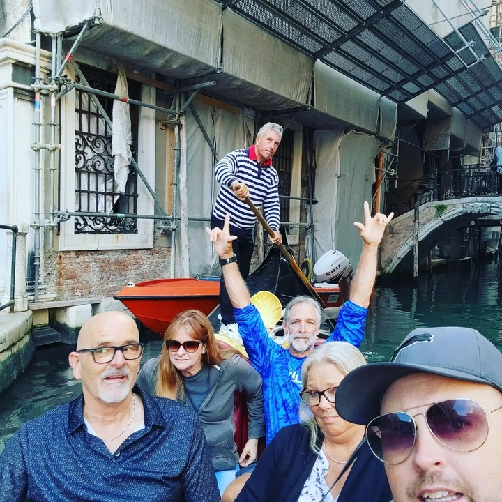 Groupe profitant d'une promenade en gondole dans un canal vénitien.