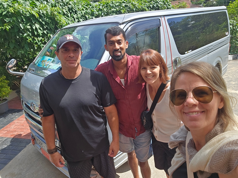 Groupe de personnes souriantes devant un véhicule.