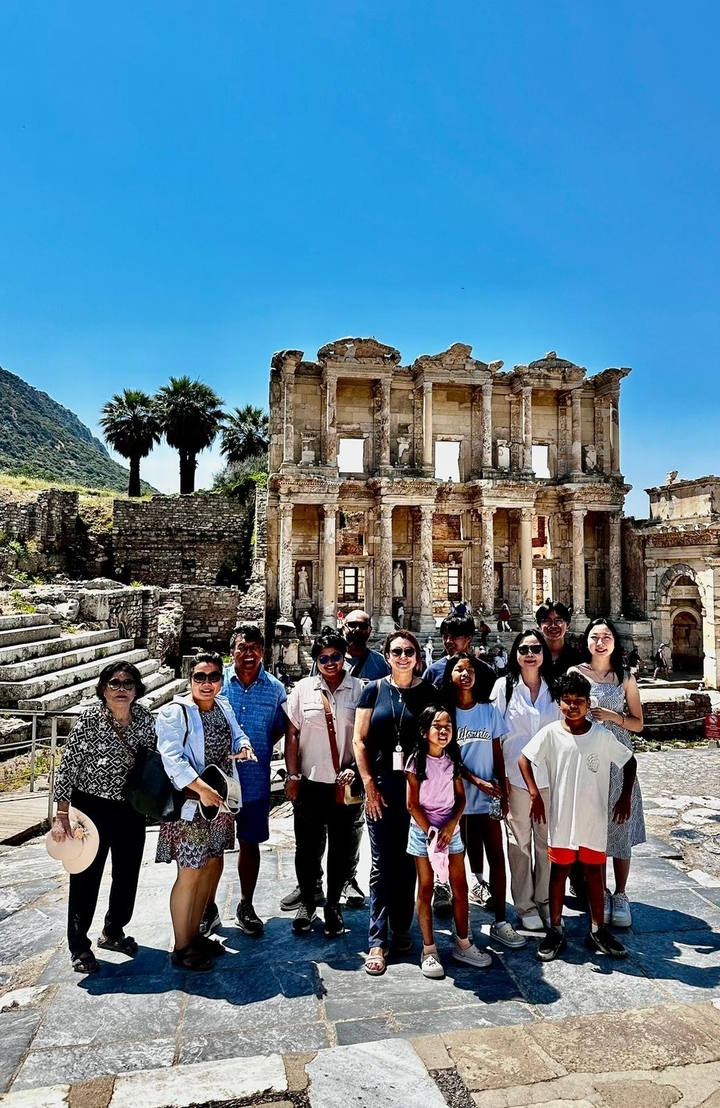 Photo de groupe devant des ruines anciennes.