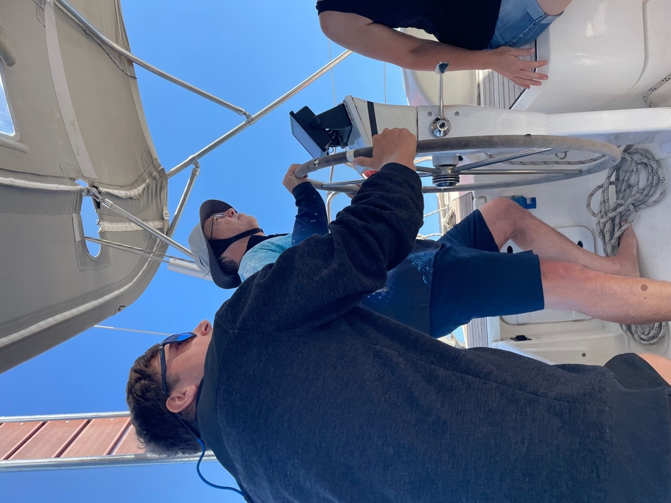 Deux personnes dirigeant un voilier.