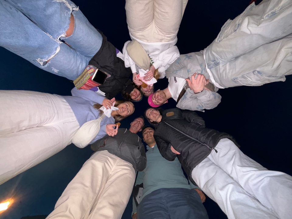 Groupe de personnes debout en cercle regardant vers le bas.