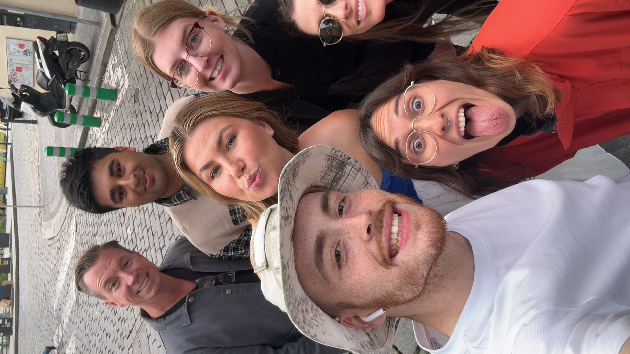 Selfie de groupe dans une rue pavée.