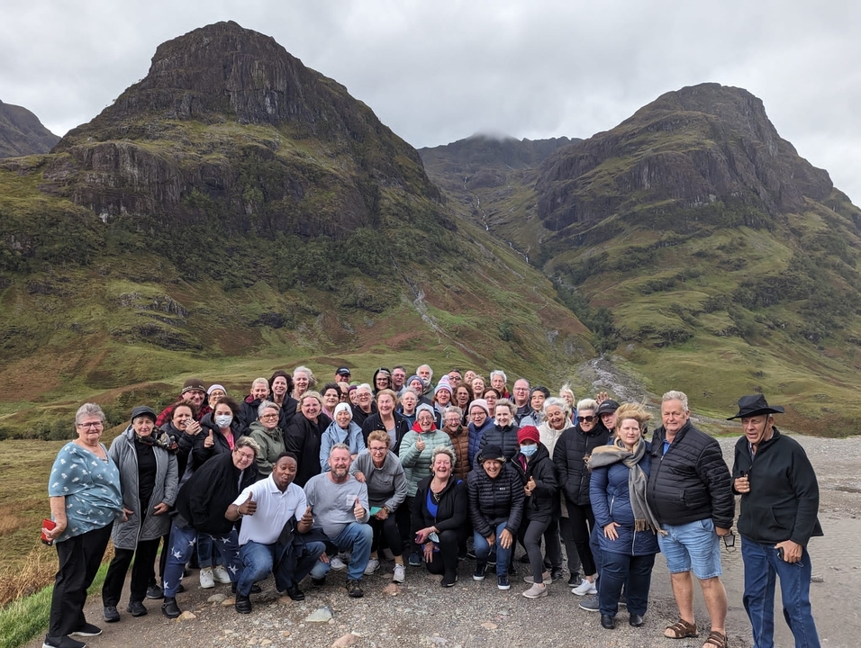 Photo de groupe nombreux devant des collines pittoresques