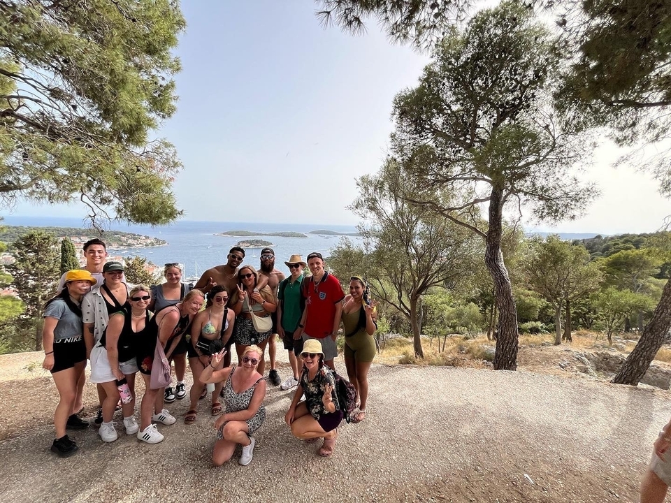 Groupe de personnes posant avec une vue panoramique sur les îles et la mer.