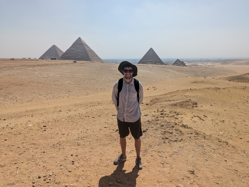 Personne debout devant des pyramides dans le désert