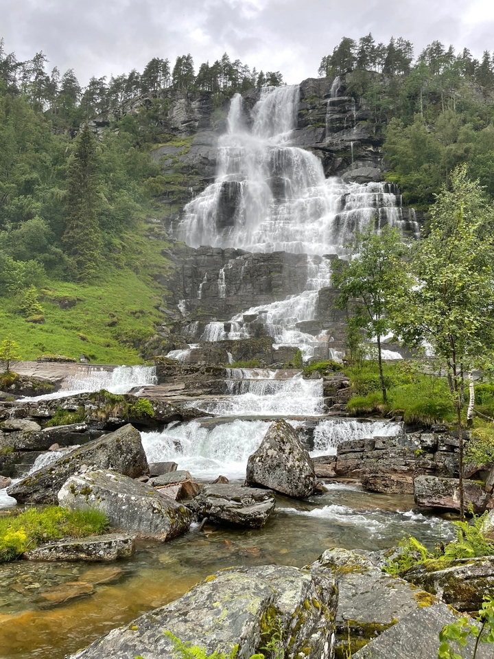 Cascade d'eau au milieu d'un paysage verdoyant.