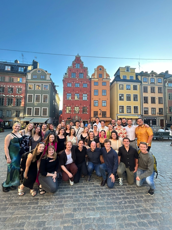 Groupe de personnes devant des bâtiments colorés.