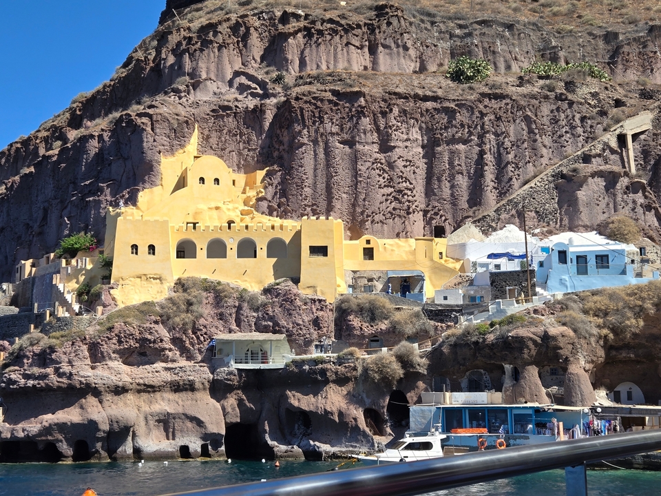 Bâtiments à flanc de falaise avec une architecture jaune unique et un terrain rocheux.