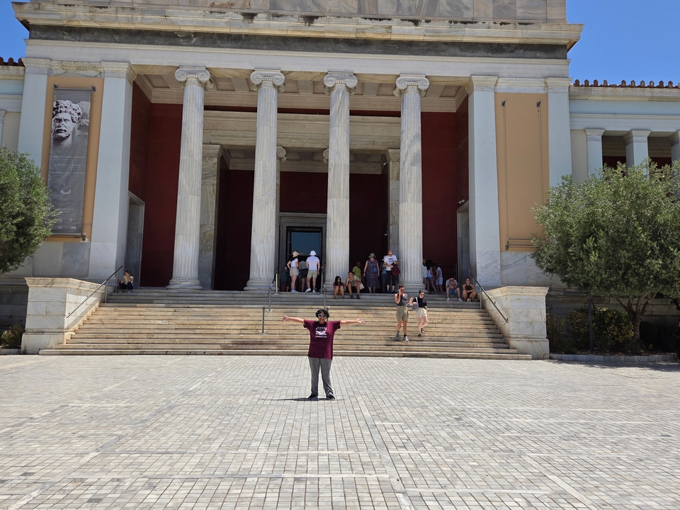 Personne qui pose devant un bâtiment classique avec des colonnes.