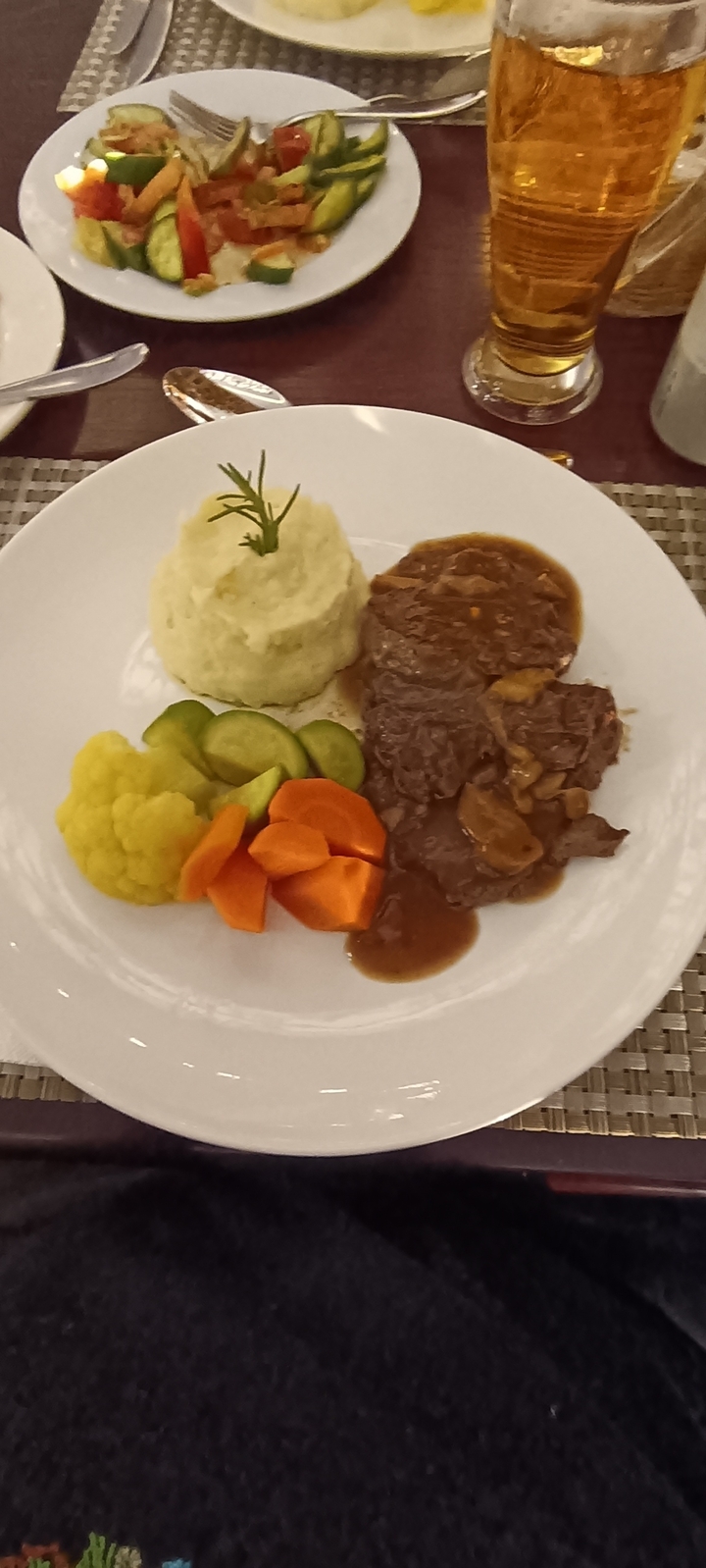 Assiette de nourriture avec purée de pommes de terre, viande et légumes.