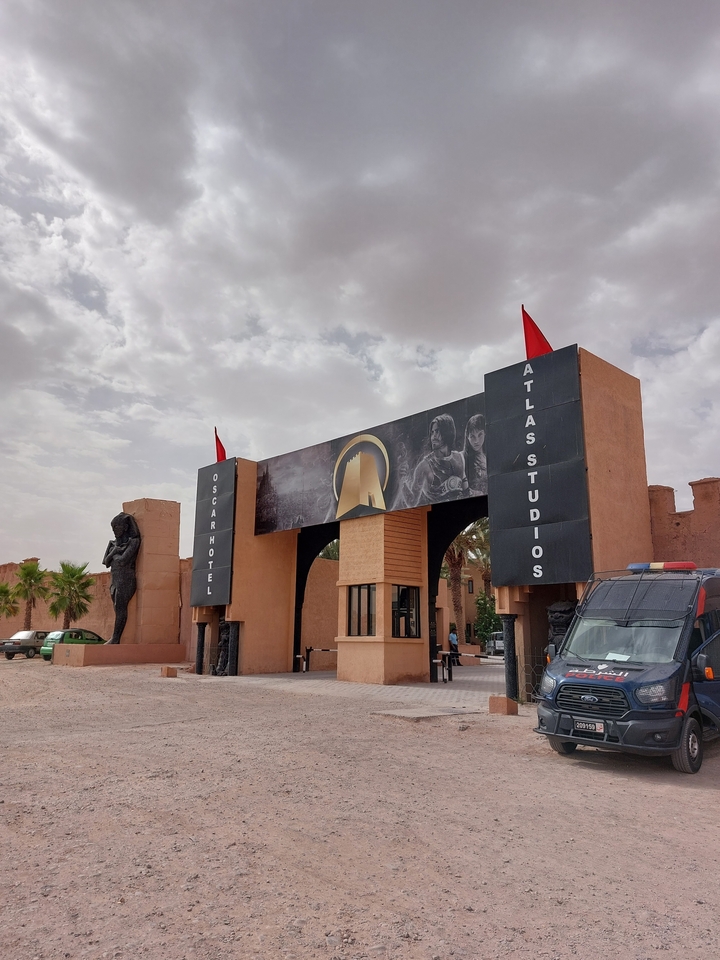 Entrée de l'Oscar Hotel aux Studios Atlas avec statues et panneaux.