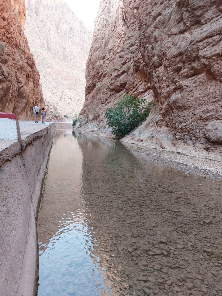 Gorge étroite avec un ruisseau peu profond et des parois rocheuses escarpées.