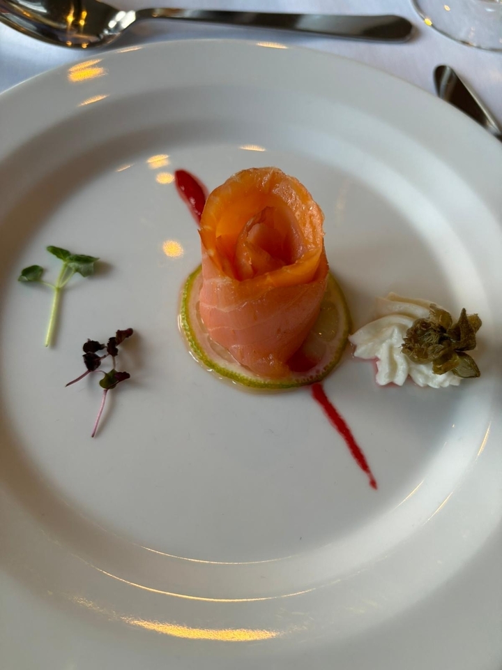 Assiette dressée avec saumon fumé, salade verte et câpres.