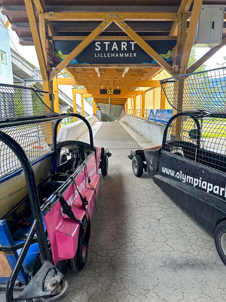 Deux bobsleighs sur une piste dans un paysage enneigé.