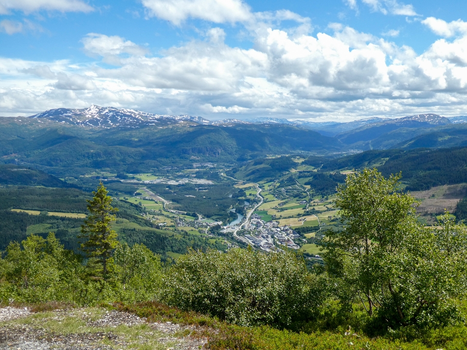 Vue panoramique d'une vallée avec des montagnes en arrière-plan.