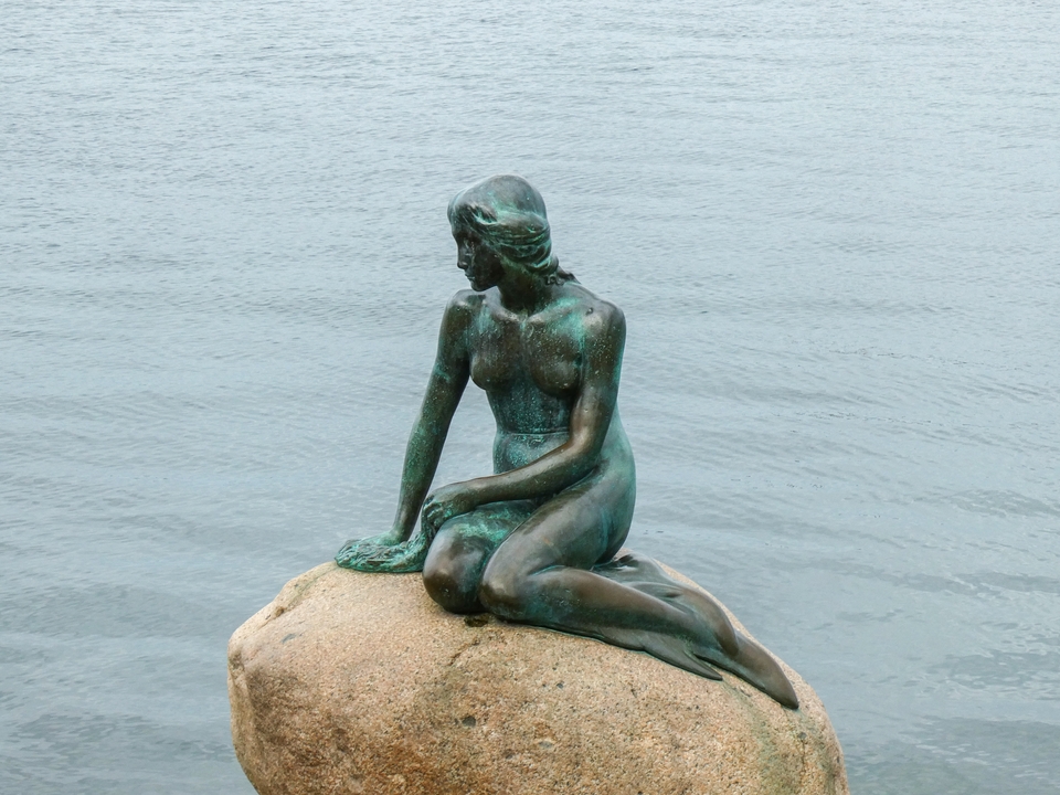 Statue d'une sirène au bord de l'eau.