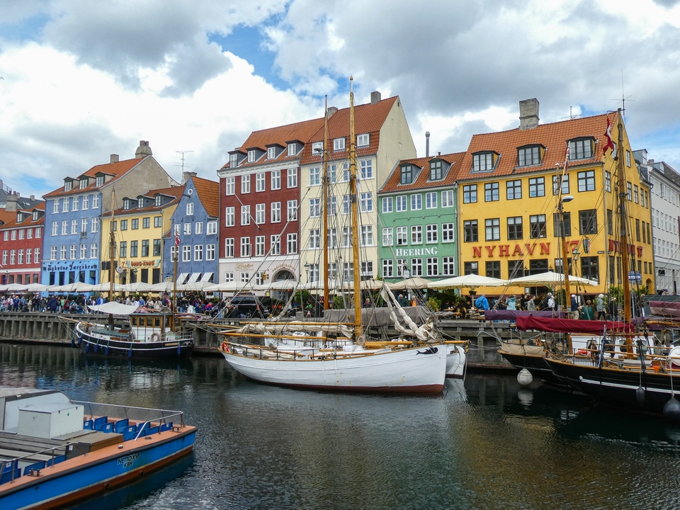 Bâtiments colorés le long du front de mer avec des bateaux amarrés.