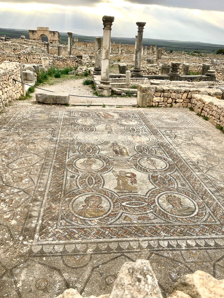 Œuvre d'art en mosaïque ancienne au sol dans un cadre historique.