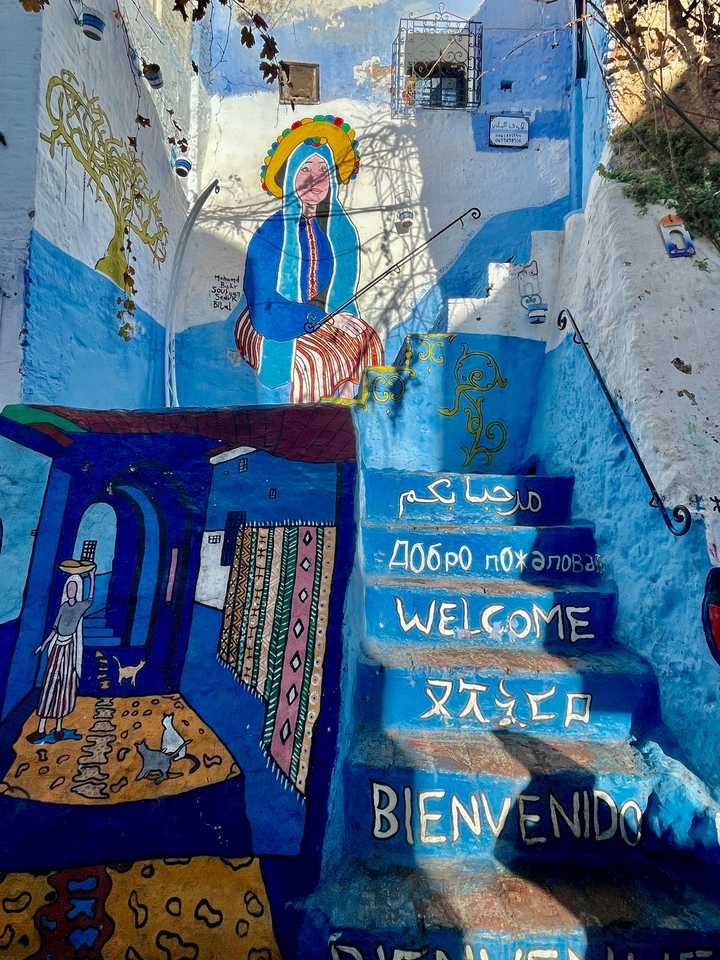 Œuvre d'art vibrante et message de bienvenue peints sur des marches dans une zone urbaine.