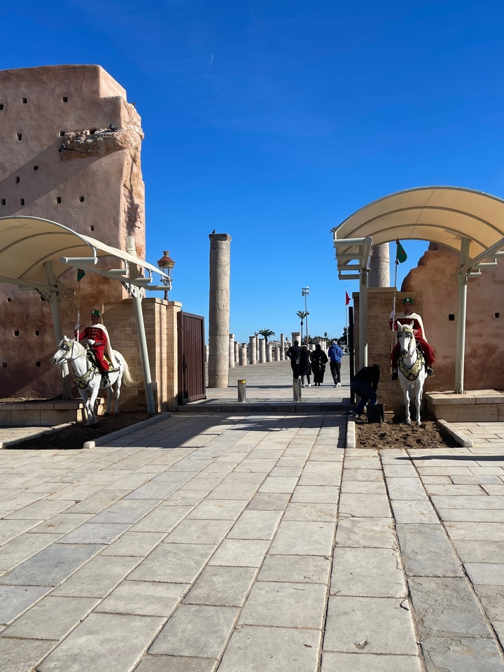 Gardes à cheval sur un site historique avec des colonnes et des arches.