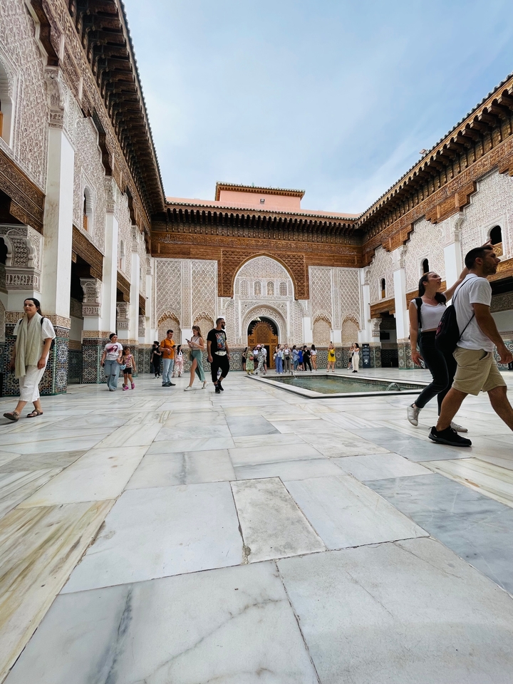 Foules dans une cour historique avec un carrelage élaboré.