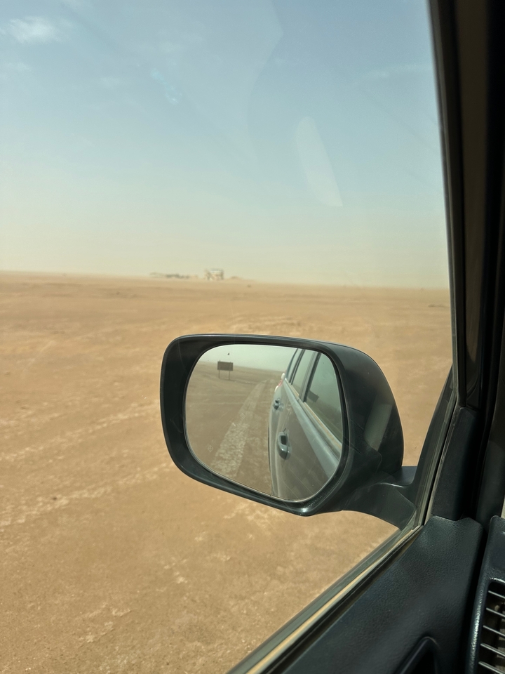 Rétroviseur d'une voiture montrant un paysage désertique.