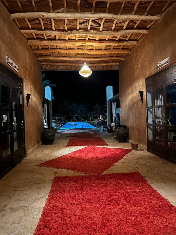 Entrée d'hôtel luxueux avec vue sur la piscine la nuit.