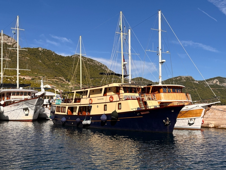 Port photogénique avec voiliers sous un ciel ensoleillé.