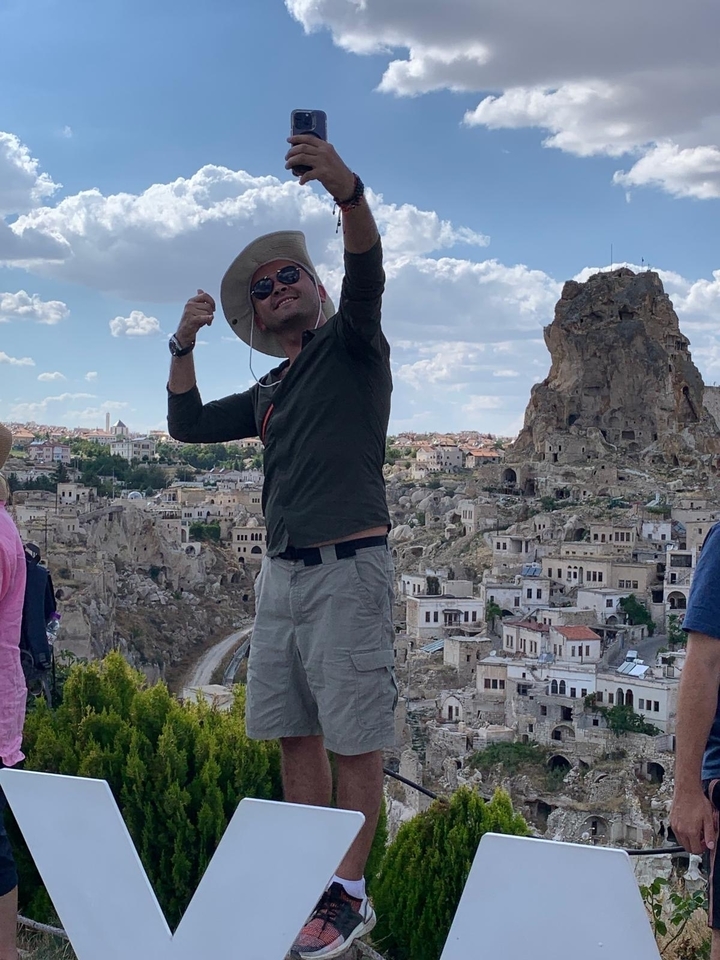 Personne prenant un selfie avec vue sur un paysage rocheux en arrière-plan.