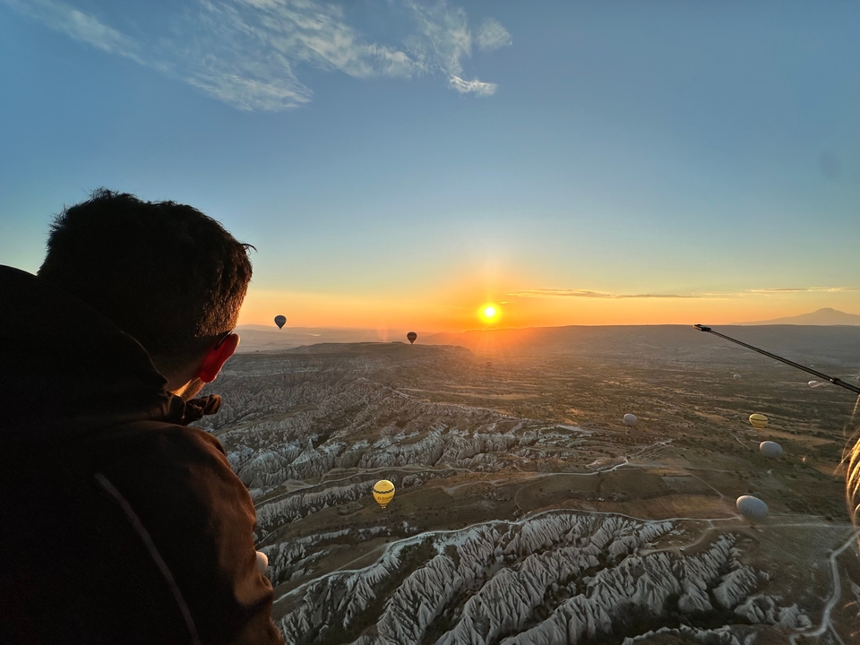 Vue depuis une montgolfière au-dessus d'un paysage rocheux au lever du soleil.