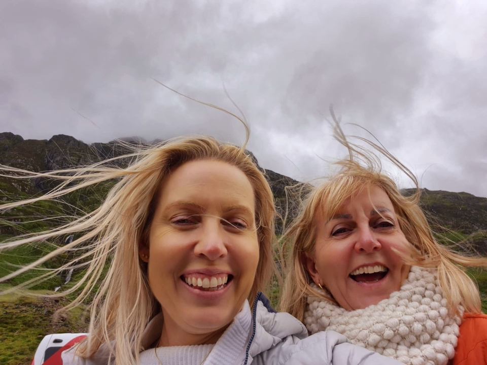 Gros plan de deux personnes aux cheveux dans le vent.