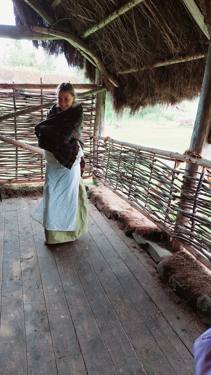 Partie d'une tenue traditionnelle avec une clôture tressée en arrière-plan.