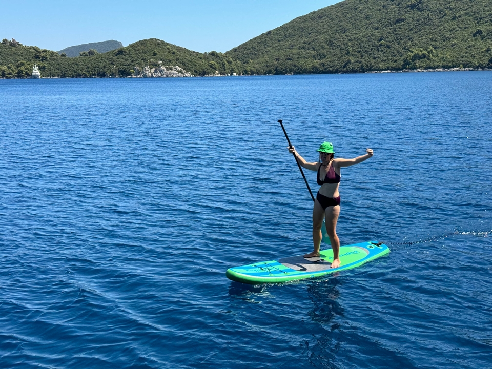 Person paddleboarding on a bright sunny day.