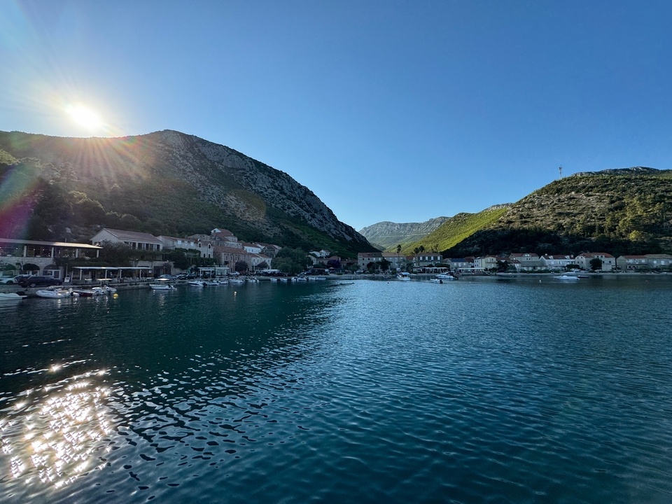 Picturesque coastal village with mountains and a setting sun.