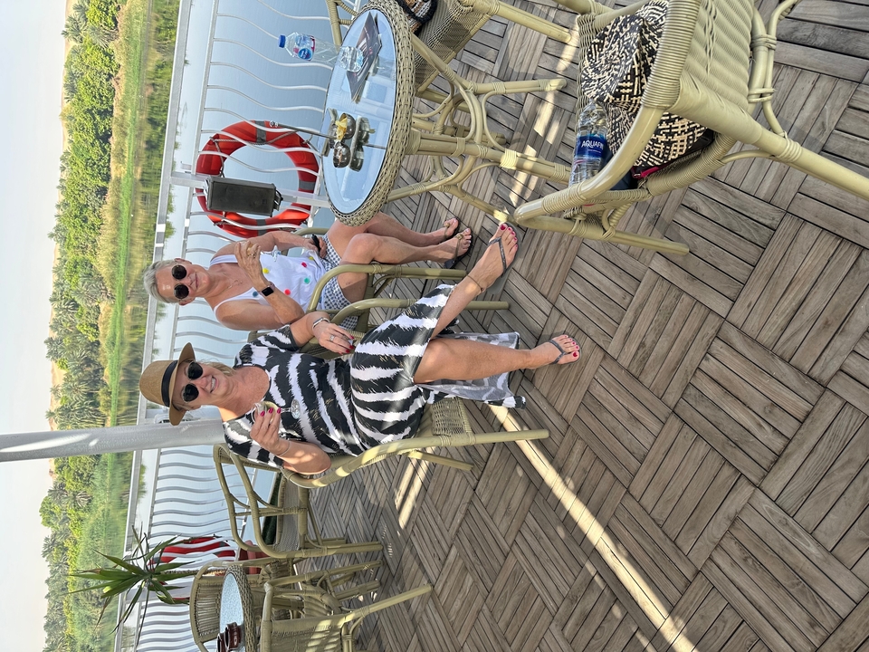 Deux personnes assises sur une terrasse avec des boissons.