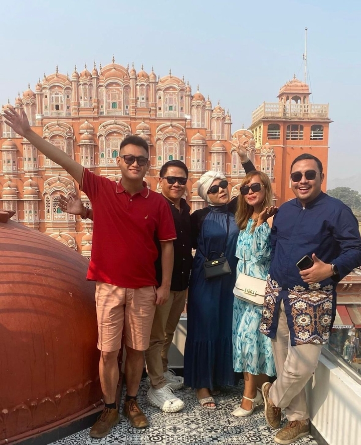 Groupe de personnes posant devant une architecture historique.