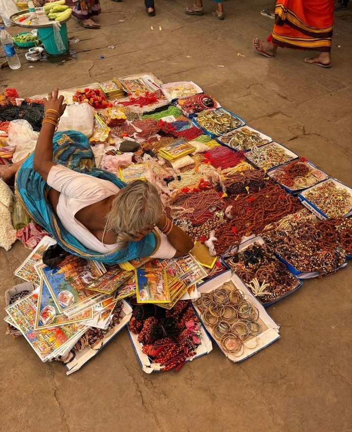 Une personne vendant divers articles colorés sur le sol.