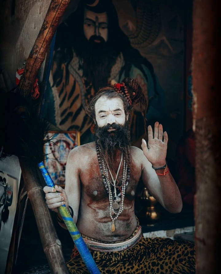 Une personne avec un visage peint et des perles traditionnelles.