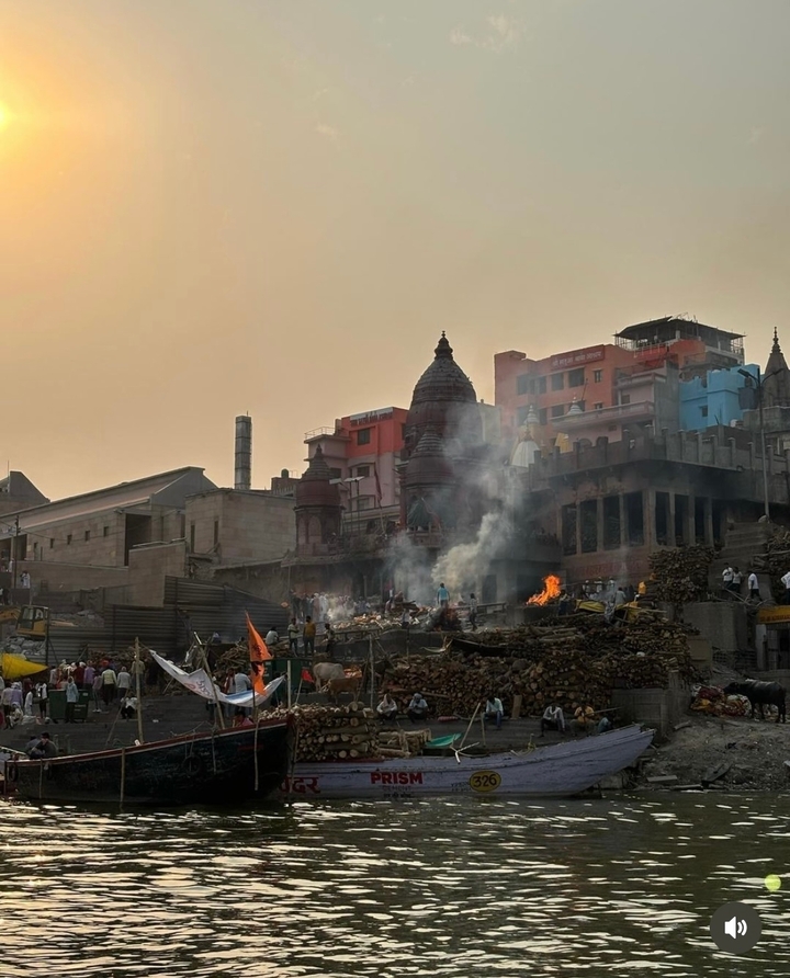 Ghat avec des gens et des bûchers funéraires en flammes au bord d'une rivière