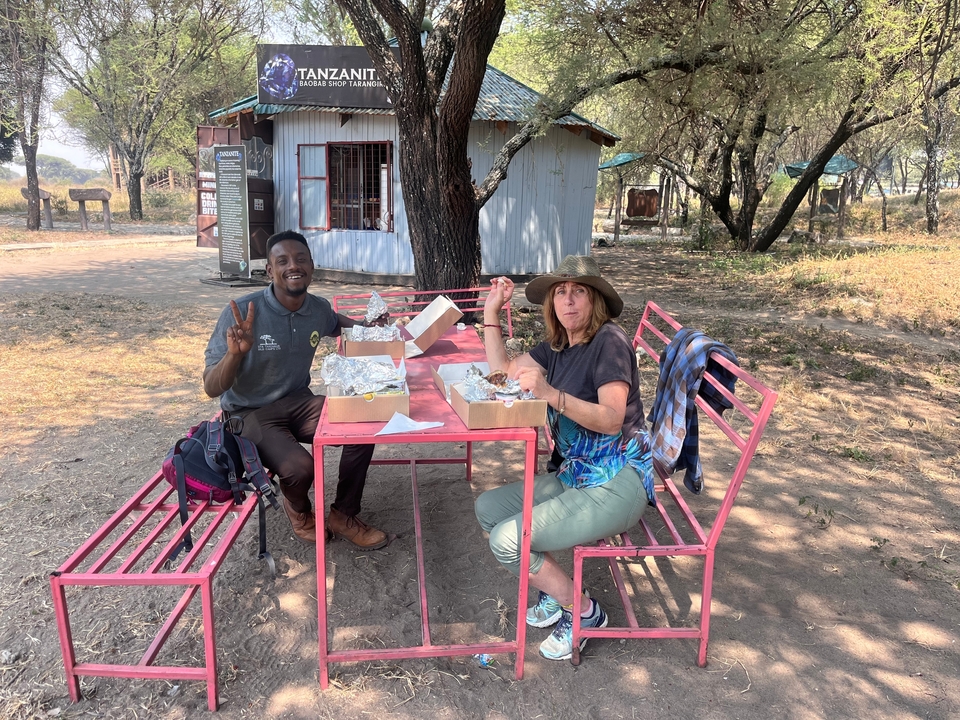 Deux personnes prenant un pique-nique sur un banc dans un parc.